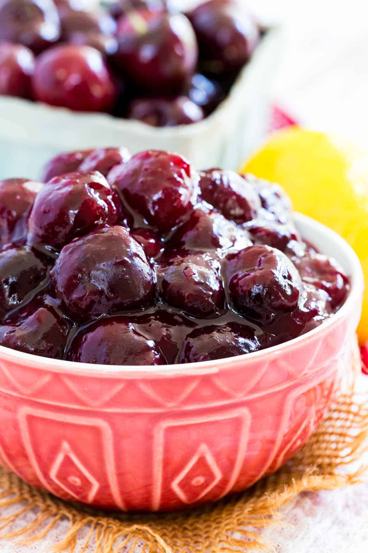 A red bowl is shown full of cherry pie filling.