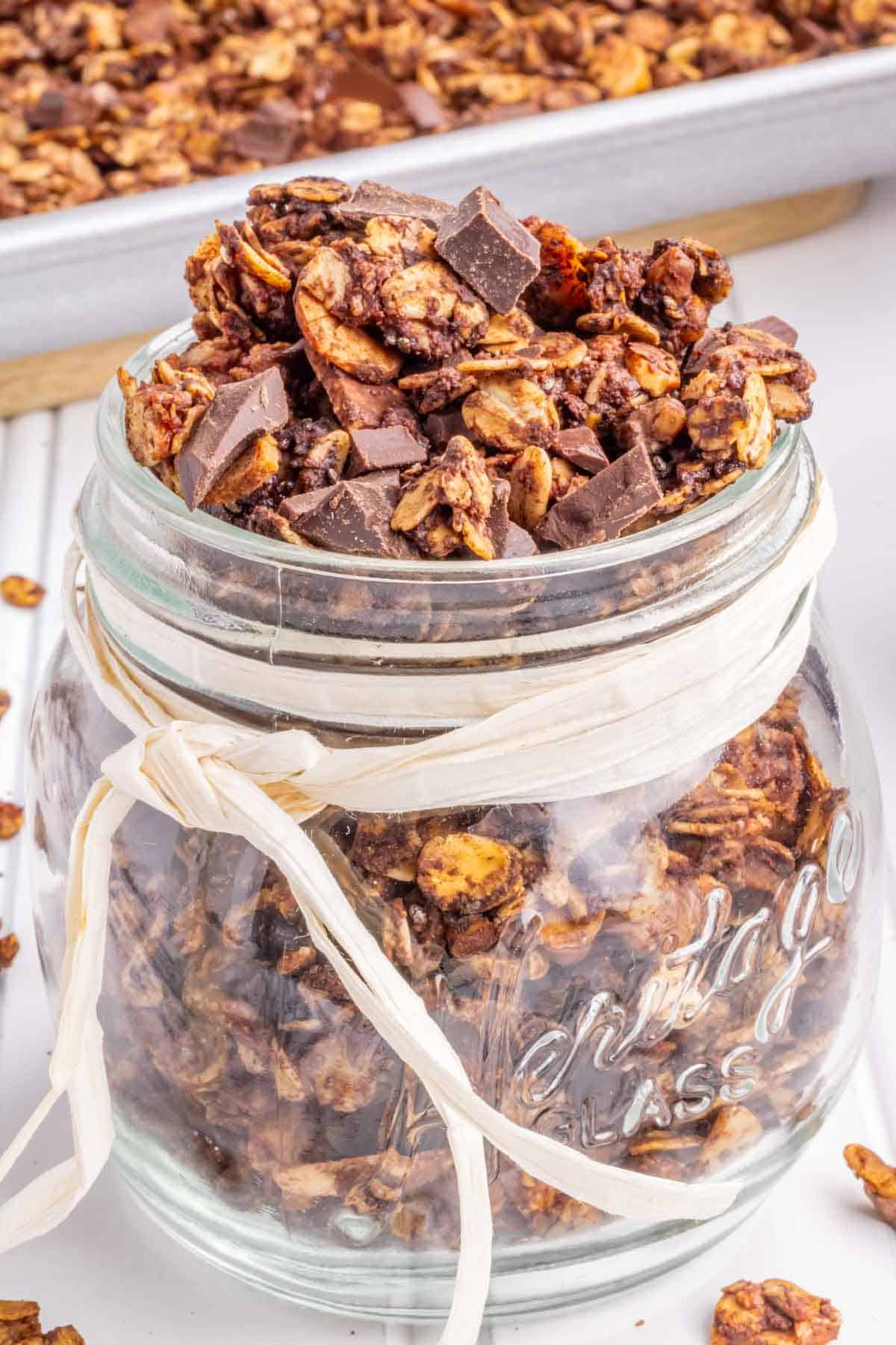 A glass jar filled with chocolate granola.