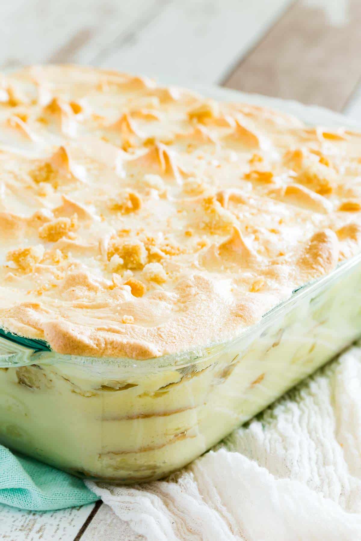 A glass pan of homemade banana pudding is shown topped with meringue.