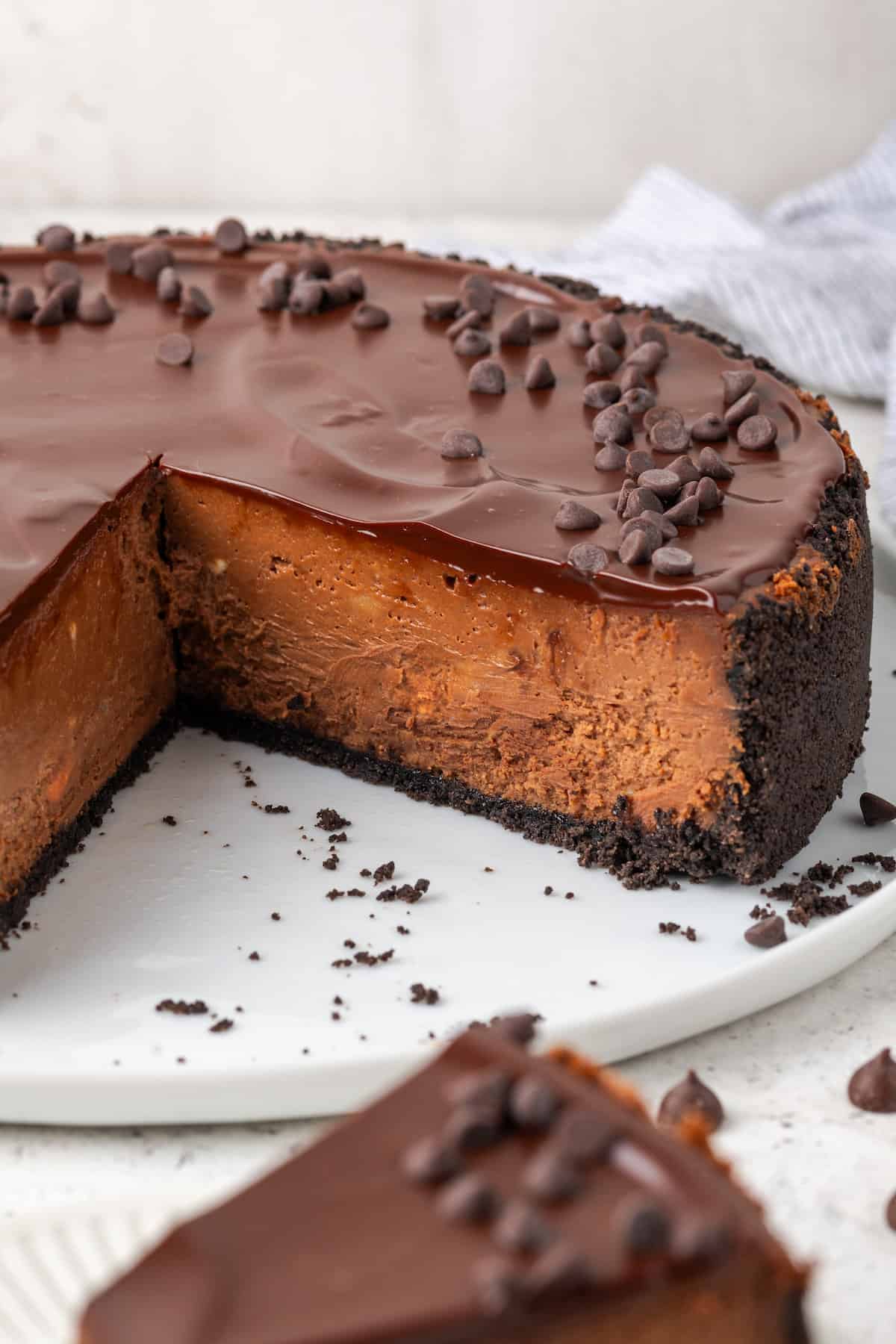 A chocolate cheesecake is shown with slices cut out of it.