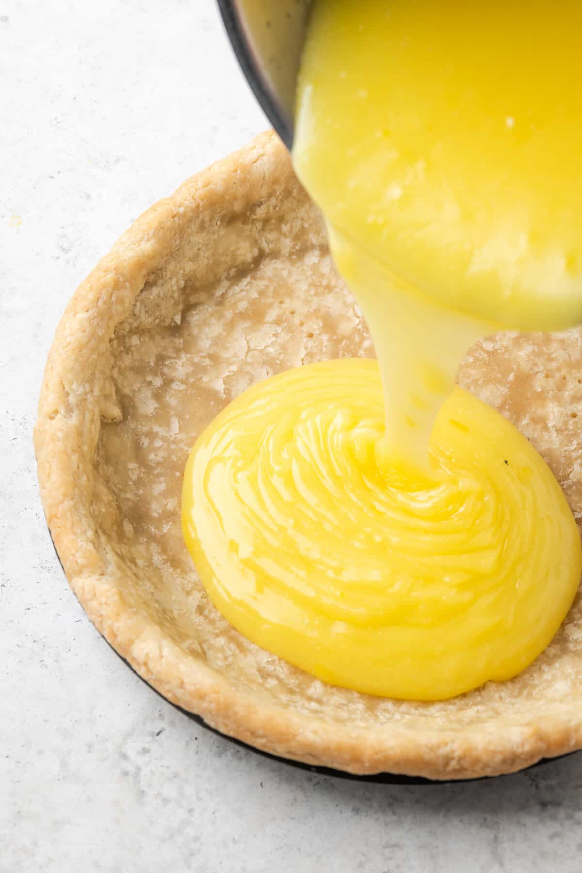 Lemon filling is poured into a pie crust to make gluten free lemon meringue pie.