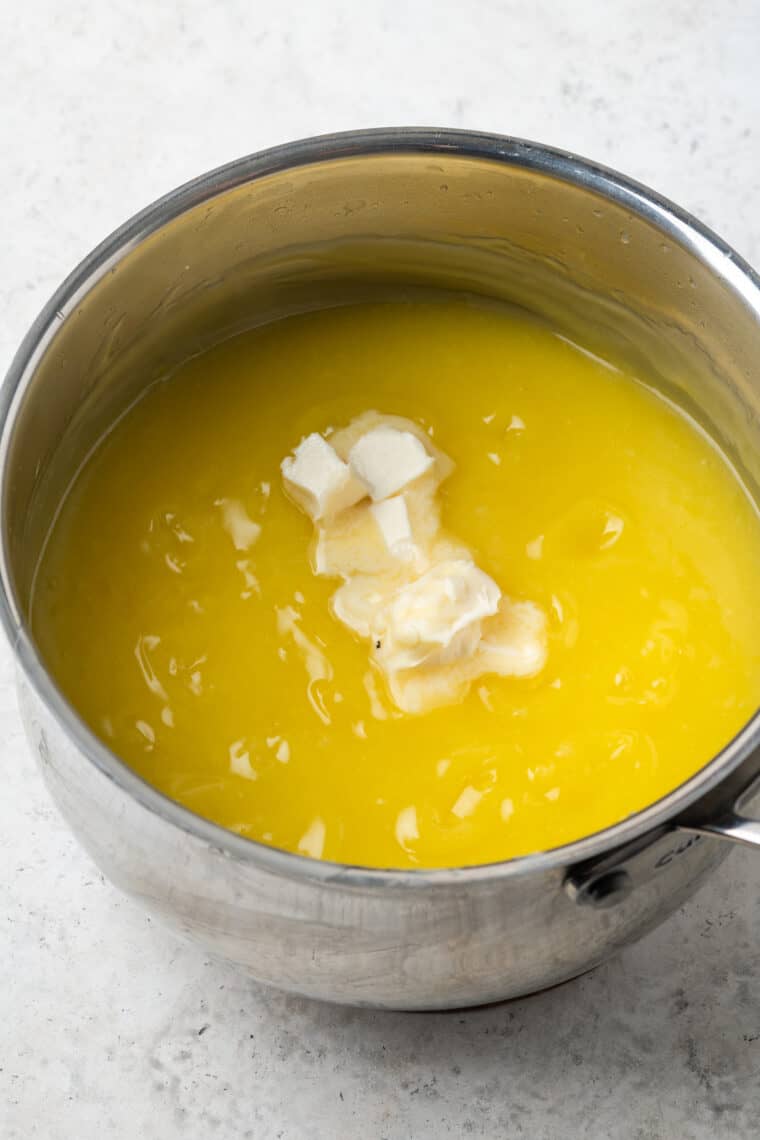 Butter sits on top of a pot of lemon filling.