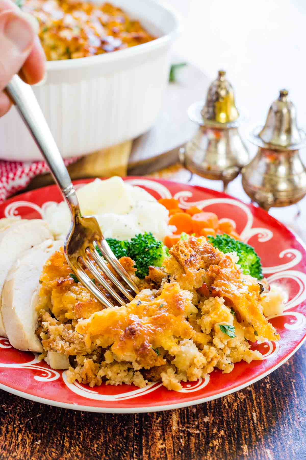 A fork dips into a plate of gluten free apple stuffing and turkey.