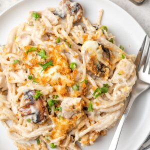 A plate of chicken tetrazzini with a fork on it.