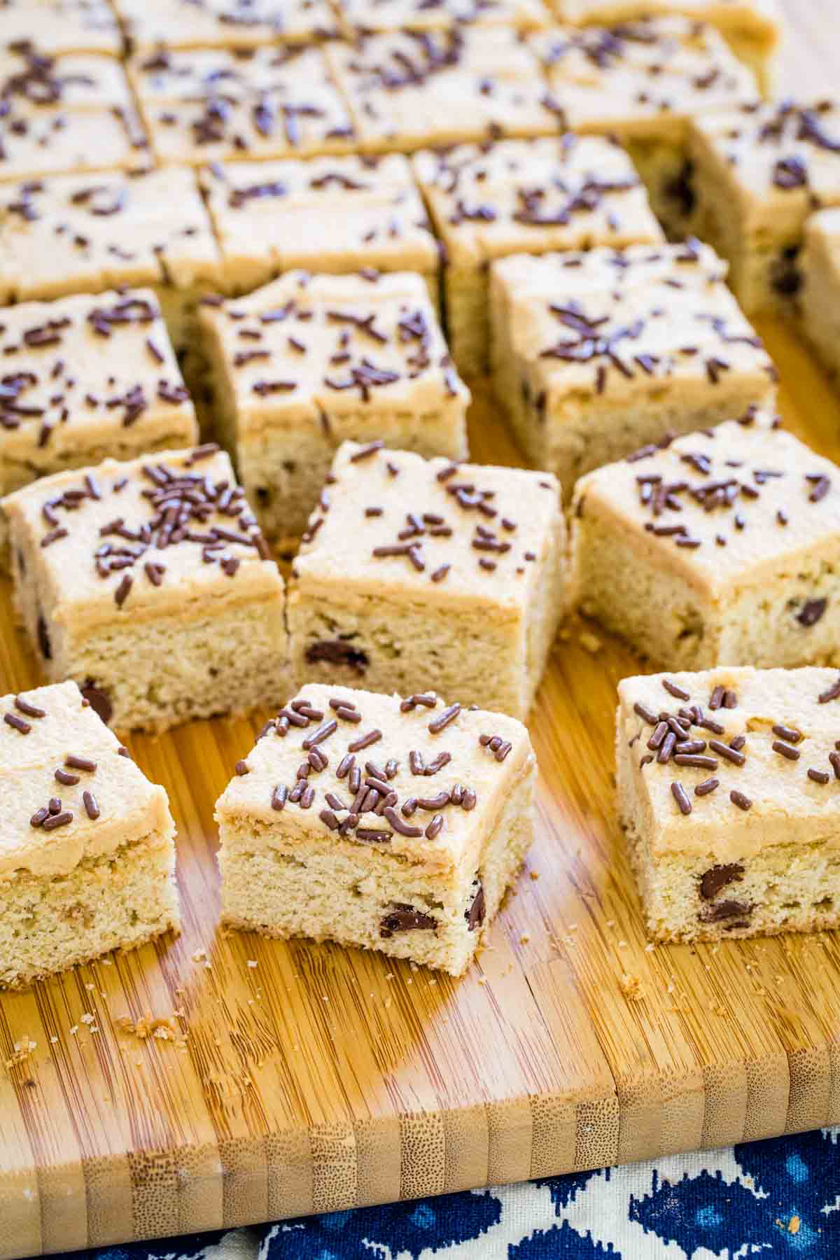 Chocolate chip cookie bars are shown on a wooden board.