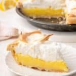 A slice of lemon meringue pie on a white plate with text overlay that says "Gluten Free Lemon Meringue Pie".