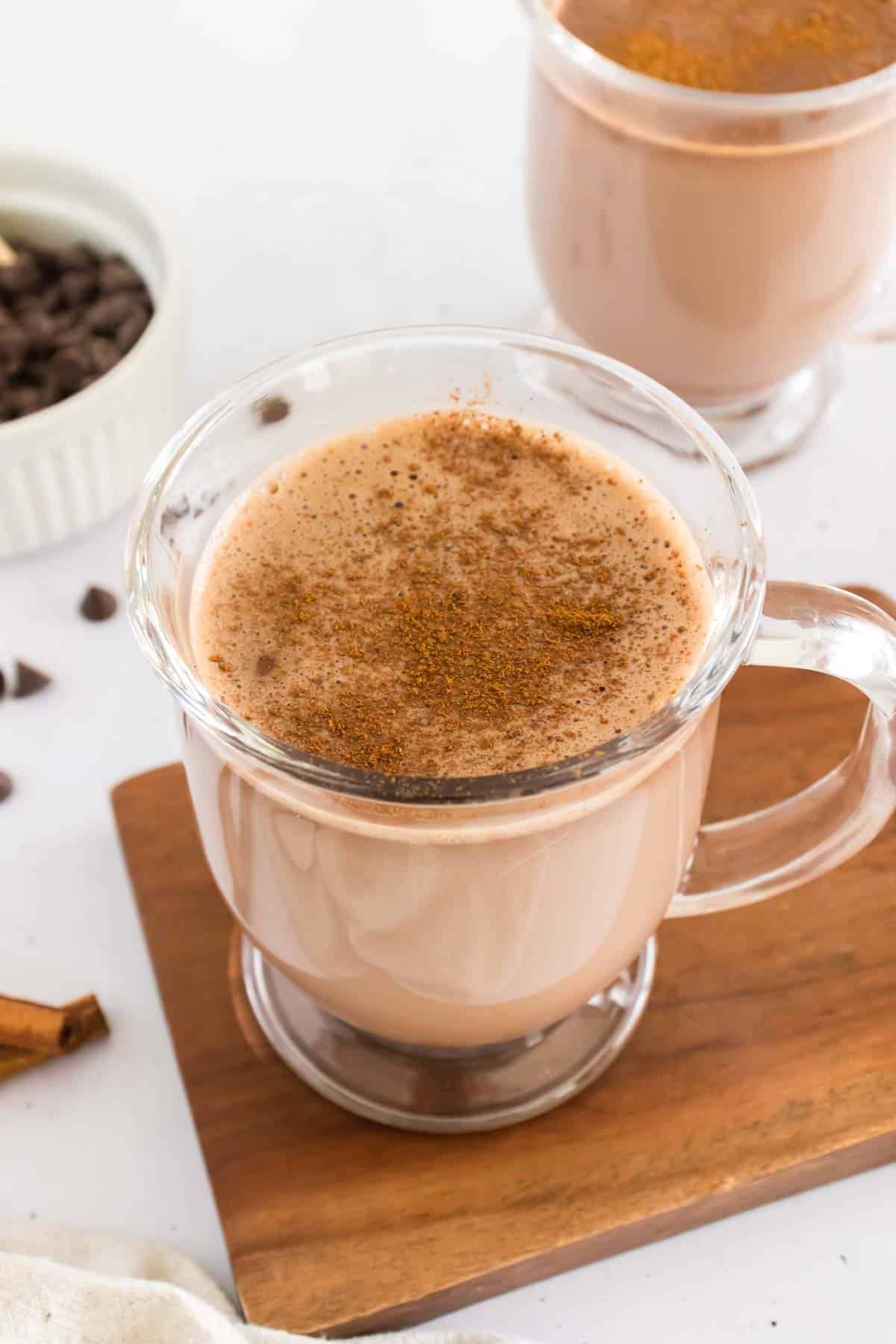 A glass of hot chocolate topped with cocoa powder.
