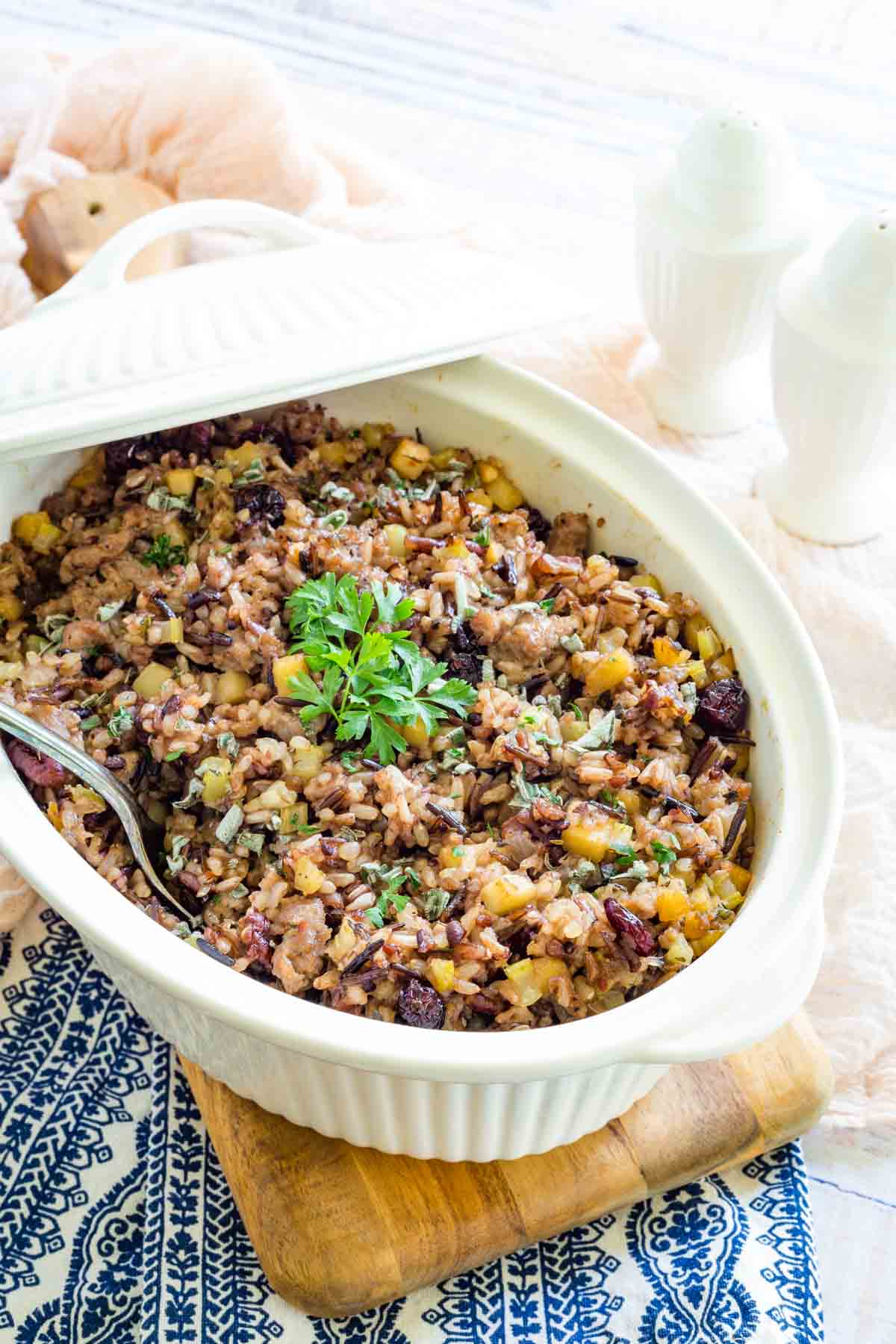 A casserole dish of wild rice stuffing with the lid raised.
