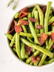 A closeup looking straight down at bacon green beans in a serving bowl.
