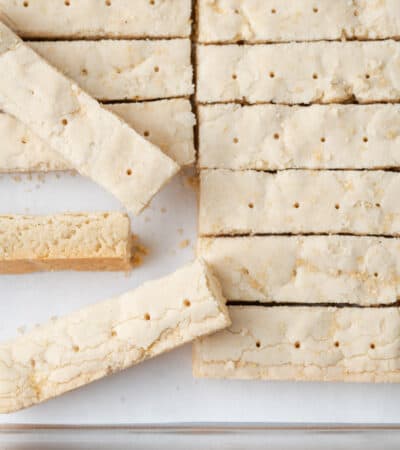 Gluten free shortbread cookies are shown on a parchment-lined pan.