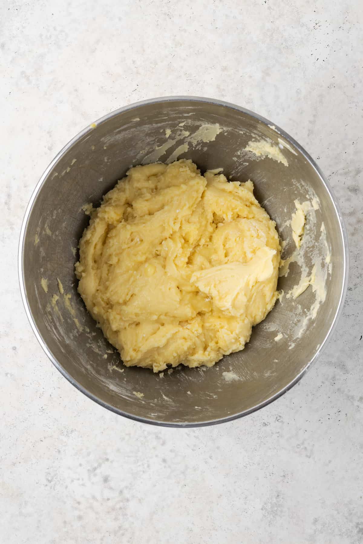 Gluten free brioche dough is shown in a metal bowl.