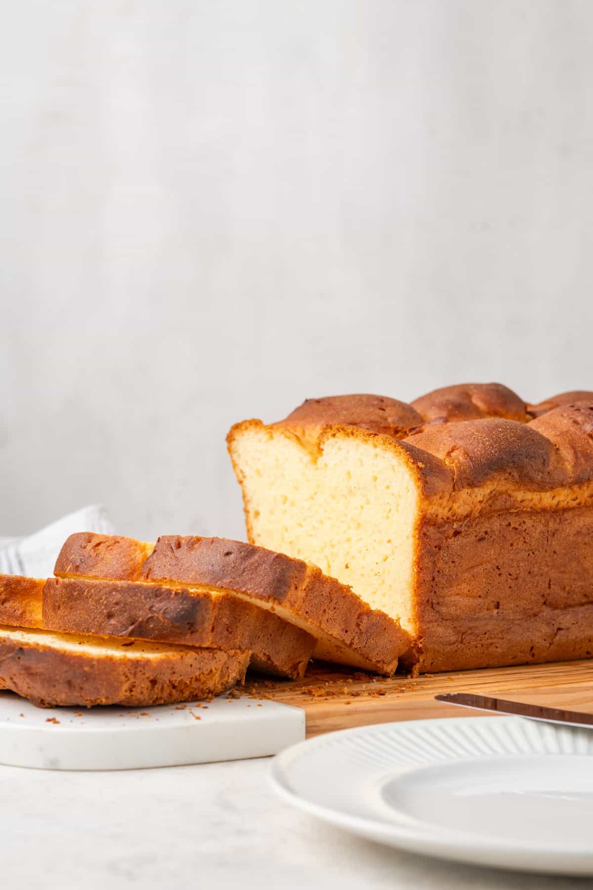 A loaf of gluten free brioche dough is shown with slices cut out of it.