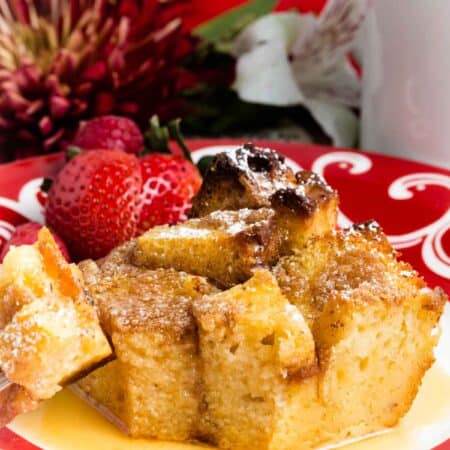 A piece of French toast casserole topped with fruit on a plate.