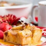 A piece of French toast casserole with syrup on a plate with text overlay that says "Gluten Free Brioche French Toast Casserole".