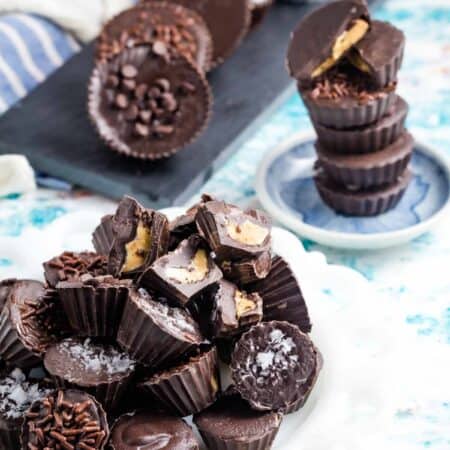 Peanut butter cups are shown on a plate with a stack in the background.