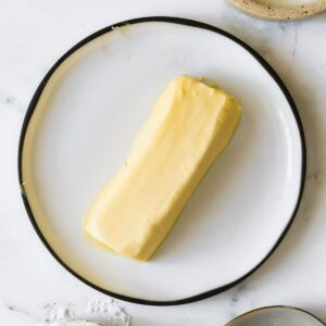 A softened stick of butter on a plate.