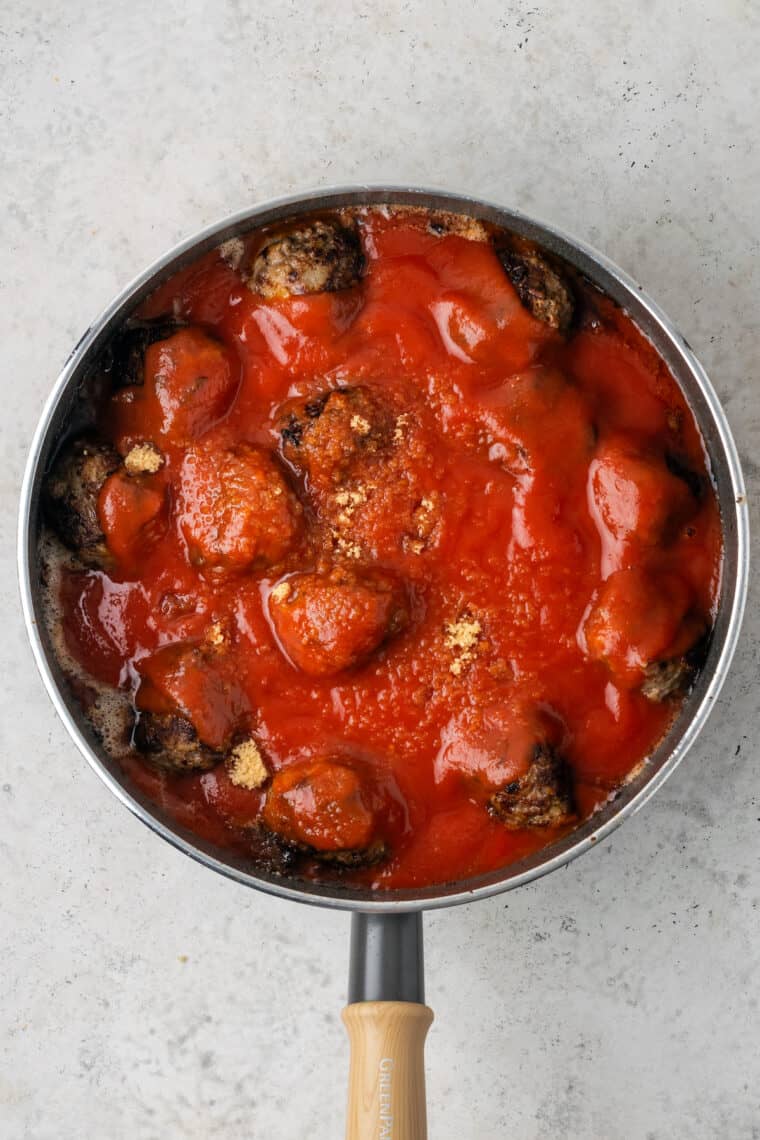 The cooked meatballs are shown after the tomato sauce has been poured over them.