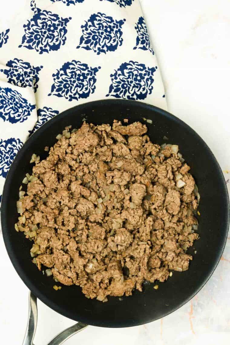 Ground beef browns in a skillet.