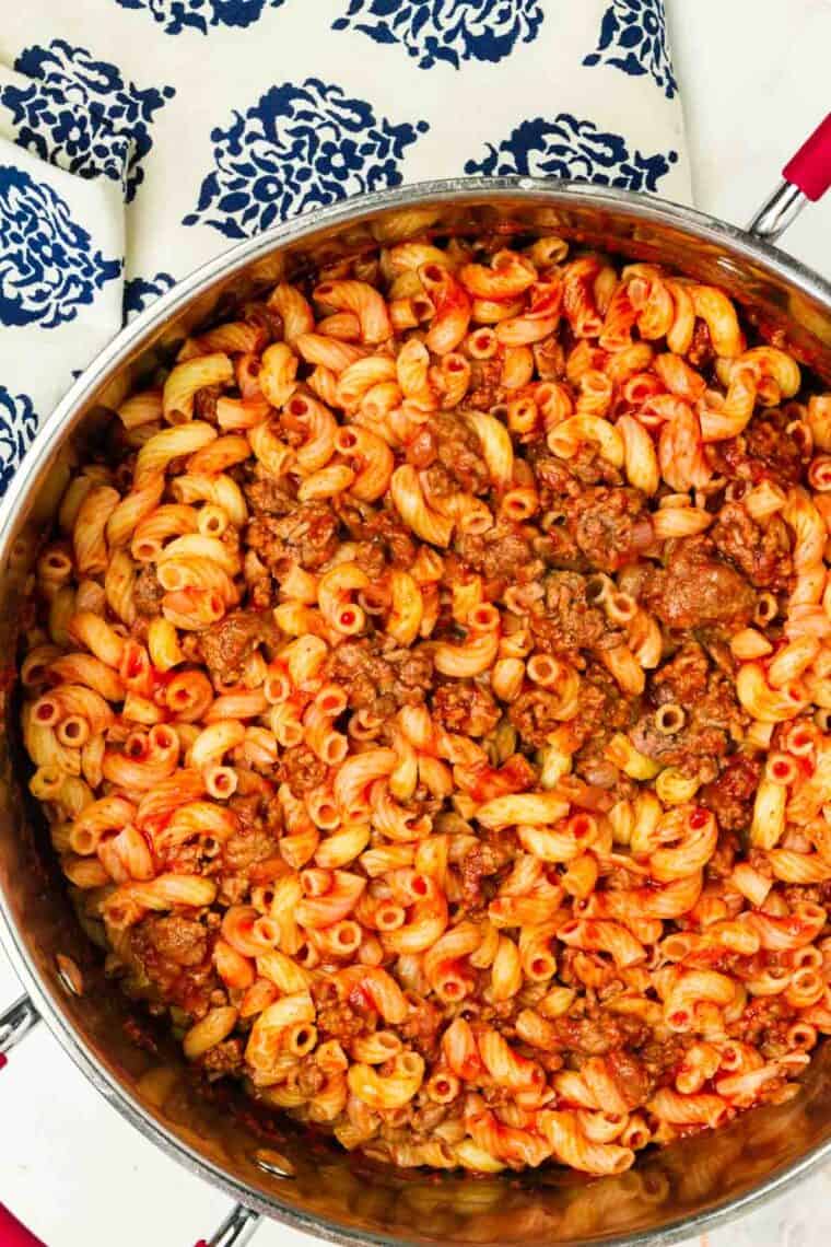 A skillet of beefaroni with meat shown on top.