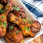 A white tray full of cooked air fryer bbq chicken legs.