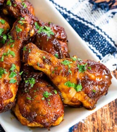 A white tray full of cooked air fryer bbq chicken legs.