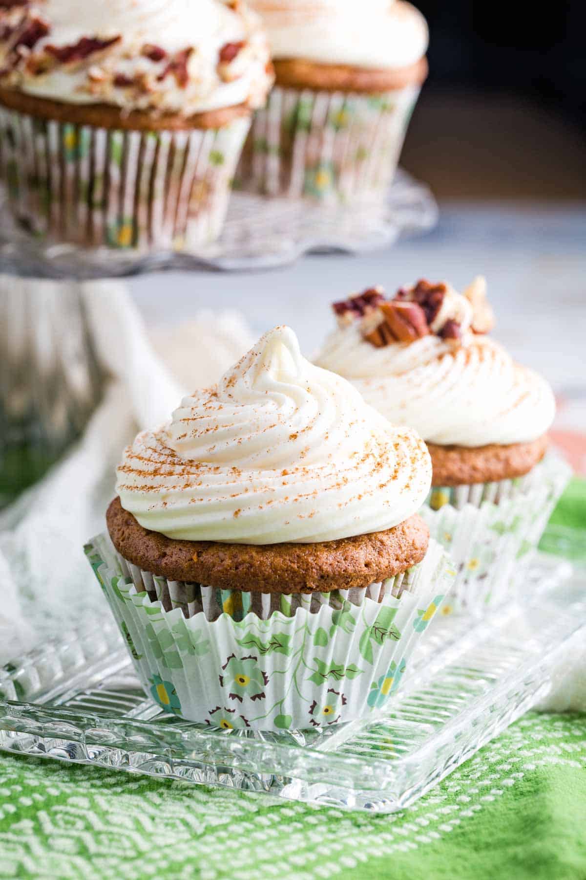 A side view of a cream cheese frosting-topped carrot cake cupcake.