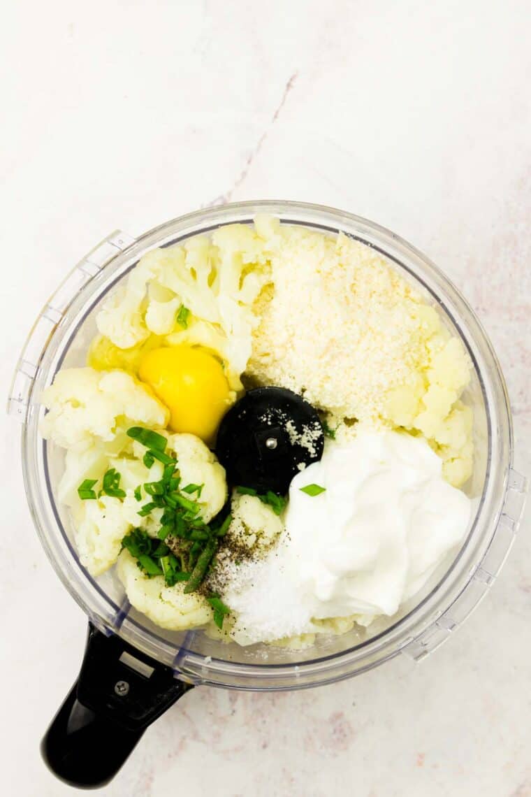 Egg, Greek yogurt, cooked cauliflower, and chives are added to a food processor.