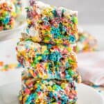 Three colorful cereal treats stacked on top of each other with text overlay that says "Fruity Pebbles Treats".