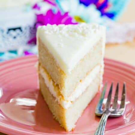 A narrow view of a piece of gluten free white cake on a plate.