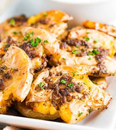Crispy smashed potatoes are served on a platter.