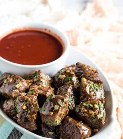 A serving tray of steak bites and dipping sauce.