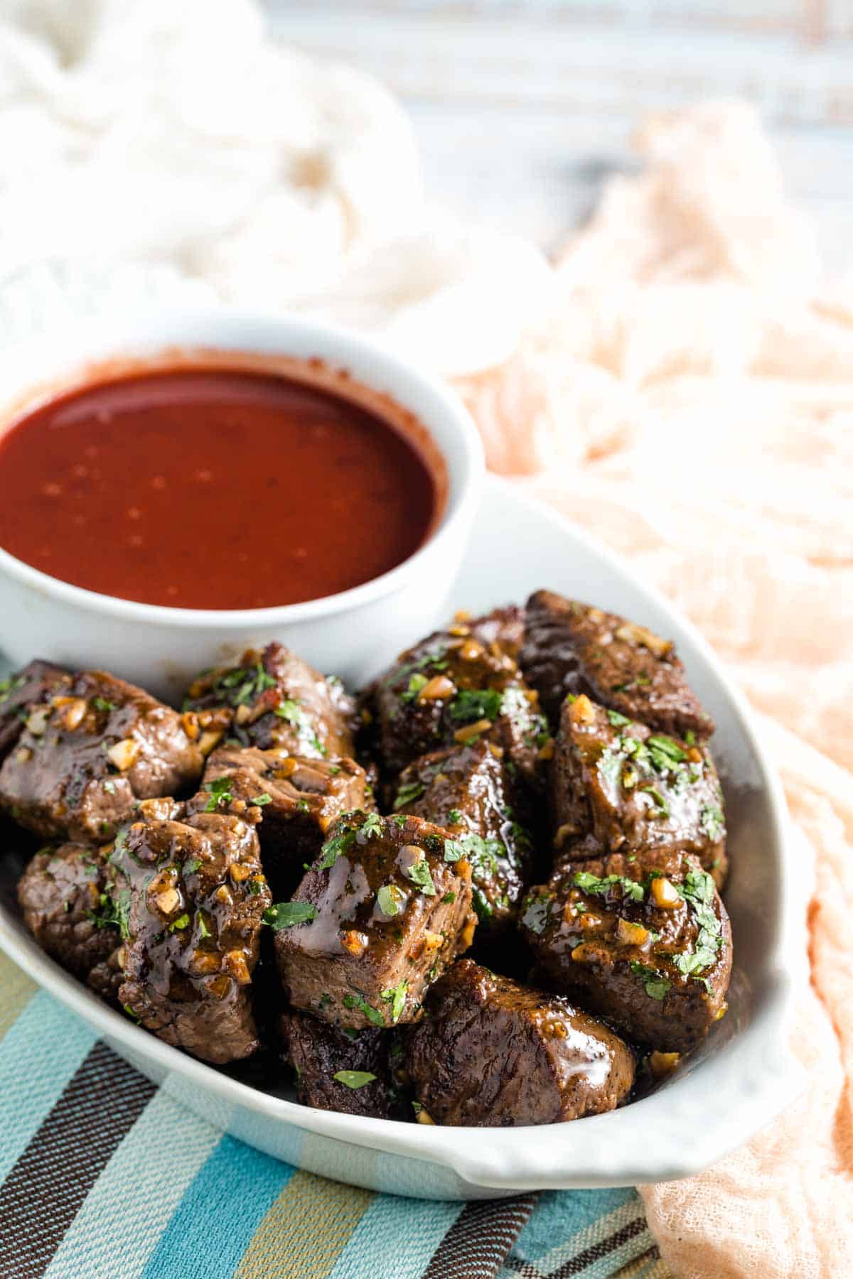 A serving tray of steak bites and dipping sauce.