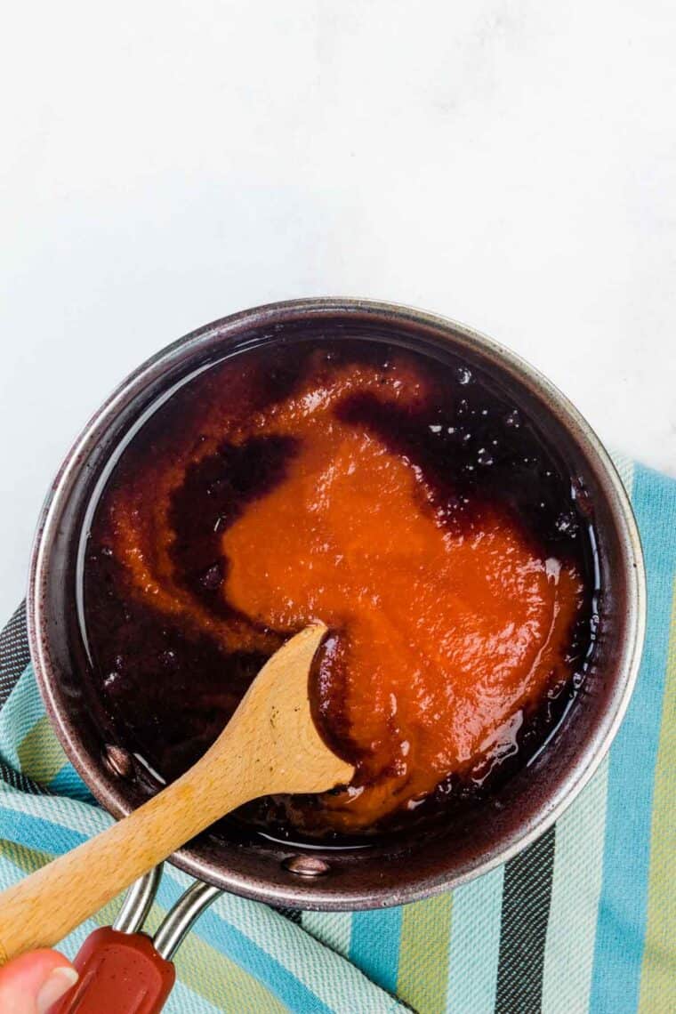 A spoon mixes the sauce.