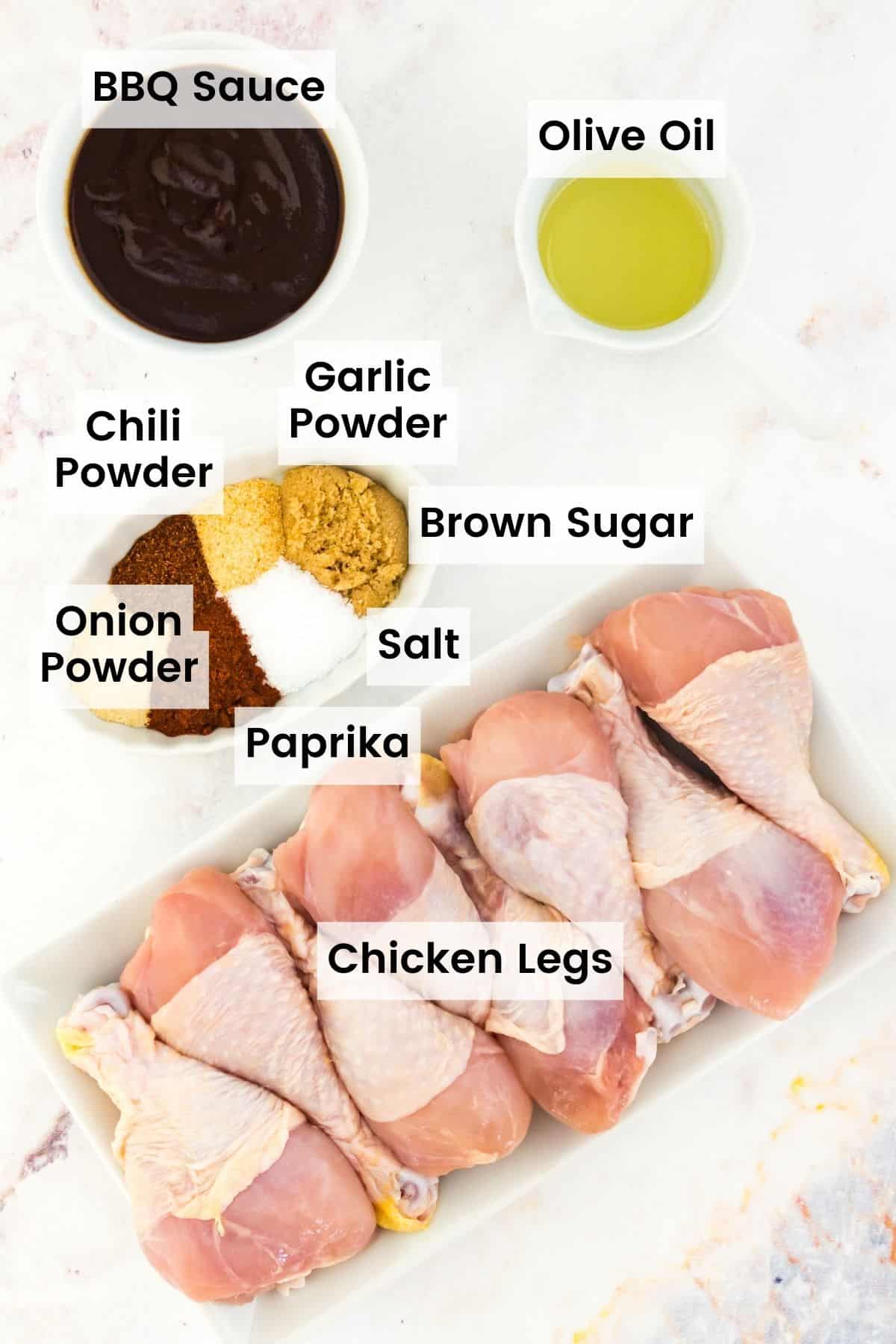 The ingredients for air fryer bbq chicken legs are shown with text labels including chicken legs, spices, bbq sauce, and oil.