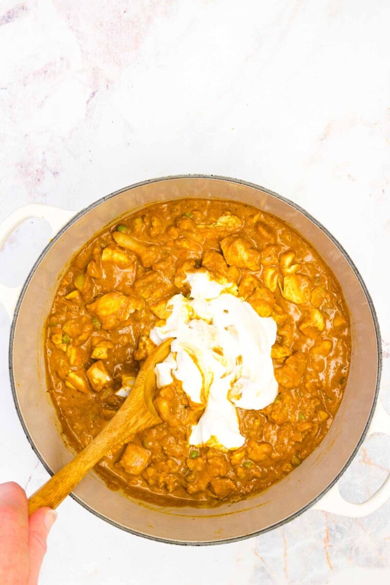 Greek yogurt is stirred into the pot of curry.