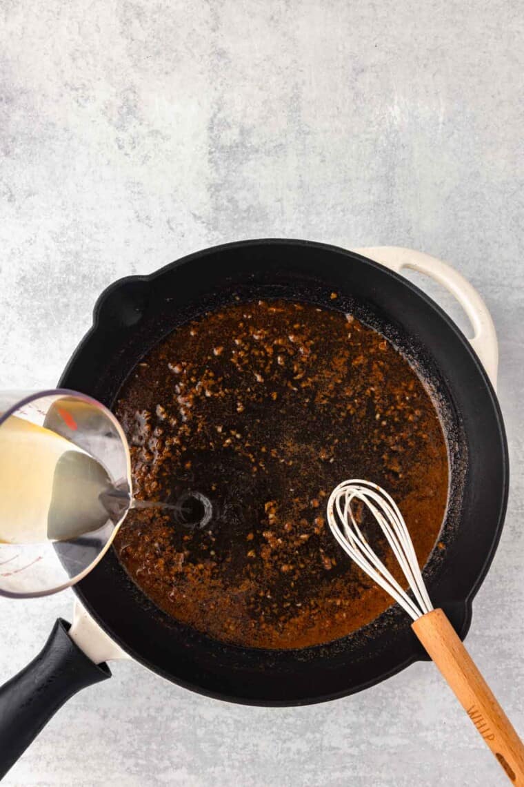 Chicken broth is whisked into the garlic butter mixture.