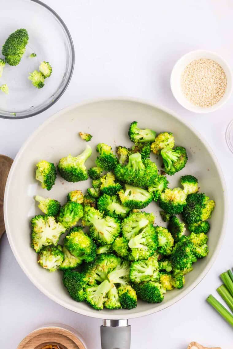 The broccoli cooks in the skillet.