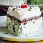 A triangular piece of mint chocolate ice cream cake on a whit plate.
