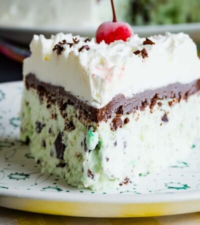 A triangular piece of mint chocolate ice cream cake on a whit plate.