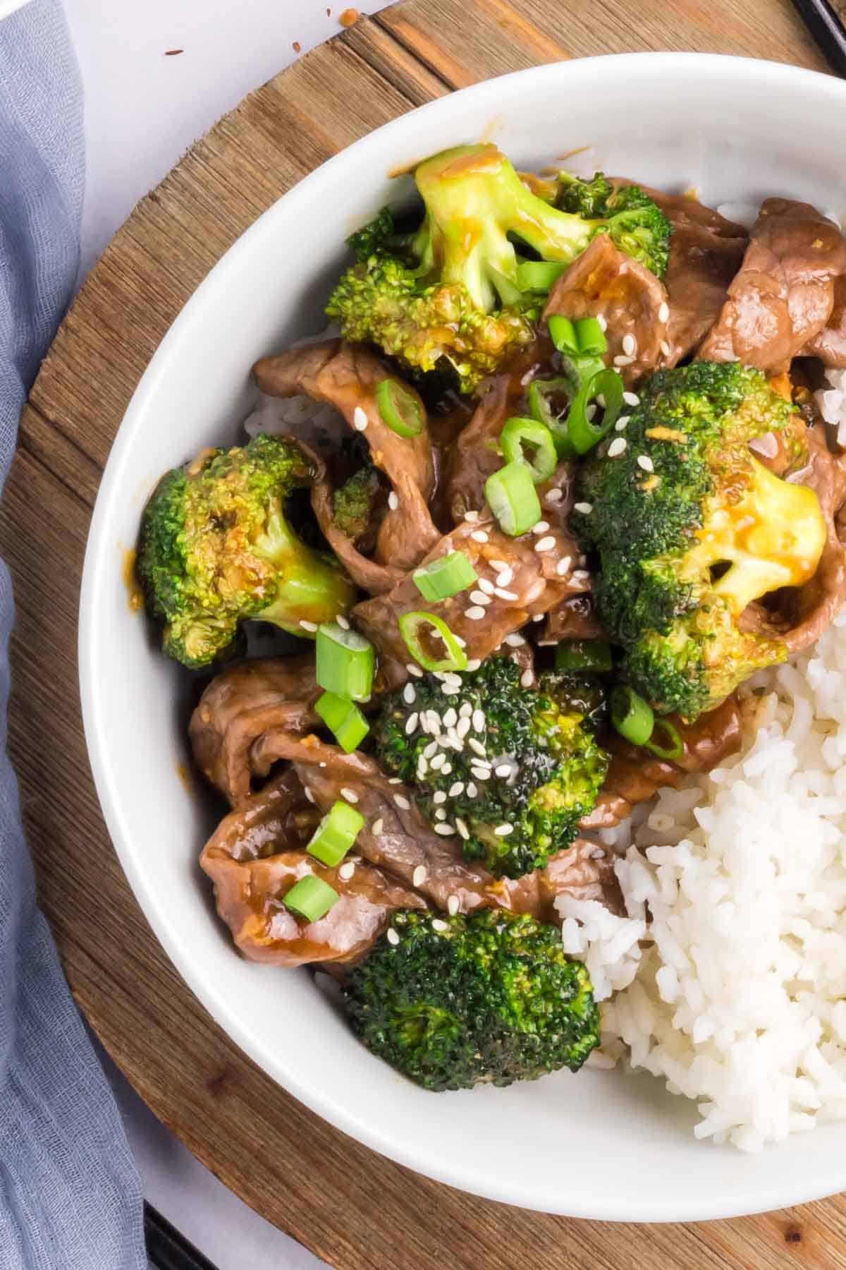 Half of a bowl of beef and broccoli with rice.