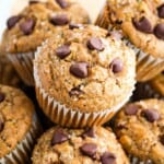 Gluten free zucchini muffins topped with chocolate chips are shown close up.