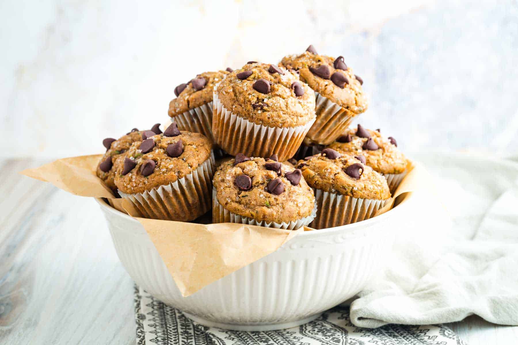 A bowl of gluten free zucchini muffins topped with chocolate chips.