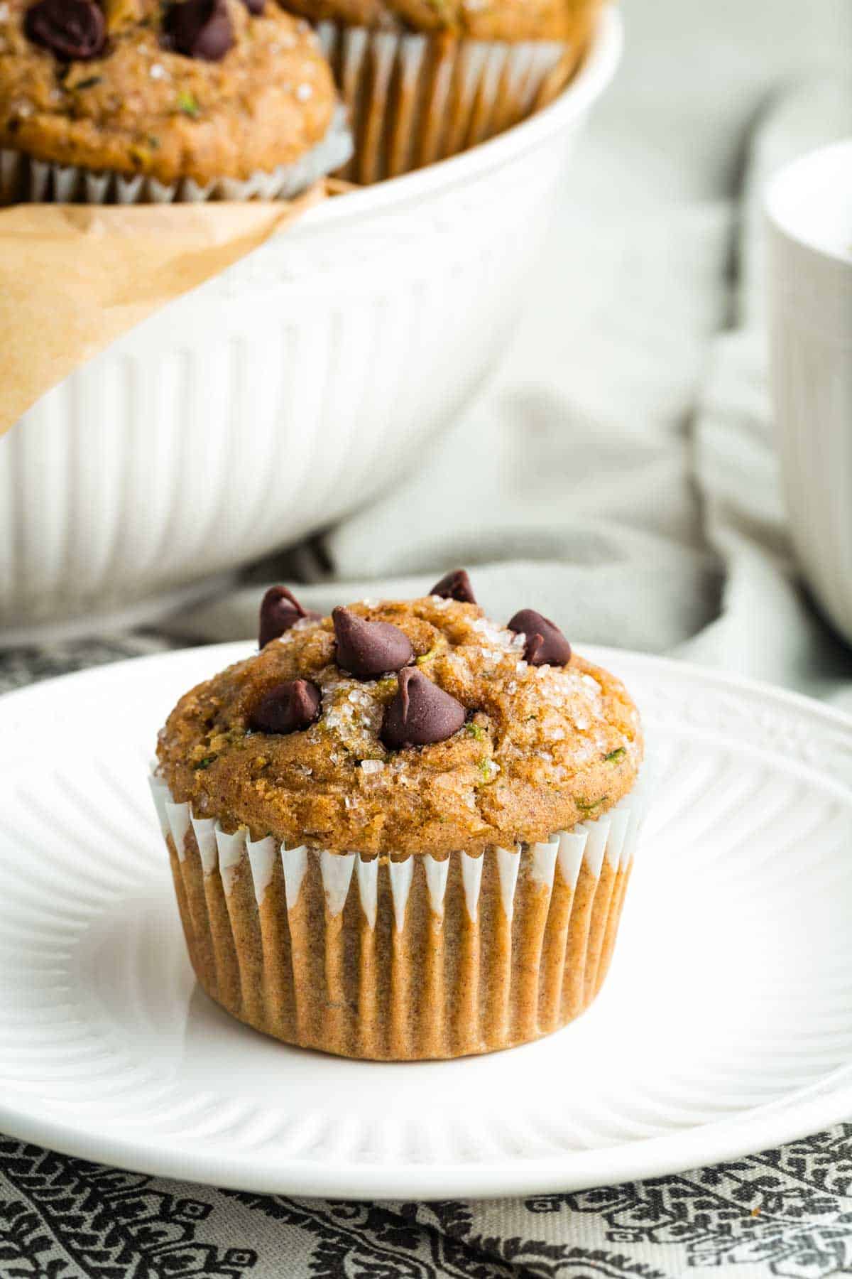 A perfectly domed gluten free zucchini muffin on a plate.