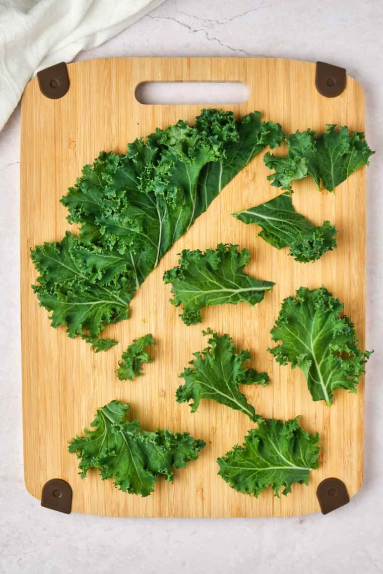 Kale pieces are chopped on a cutting board.