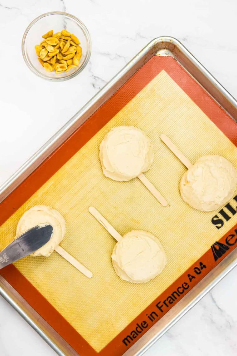 An offset spatula presses the peanut butter and yogurt mixture on top of the first dollop.