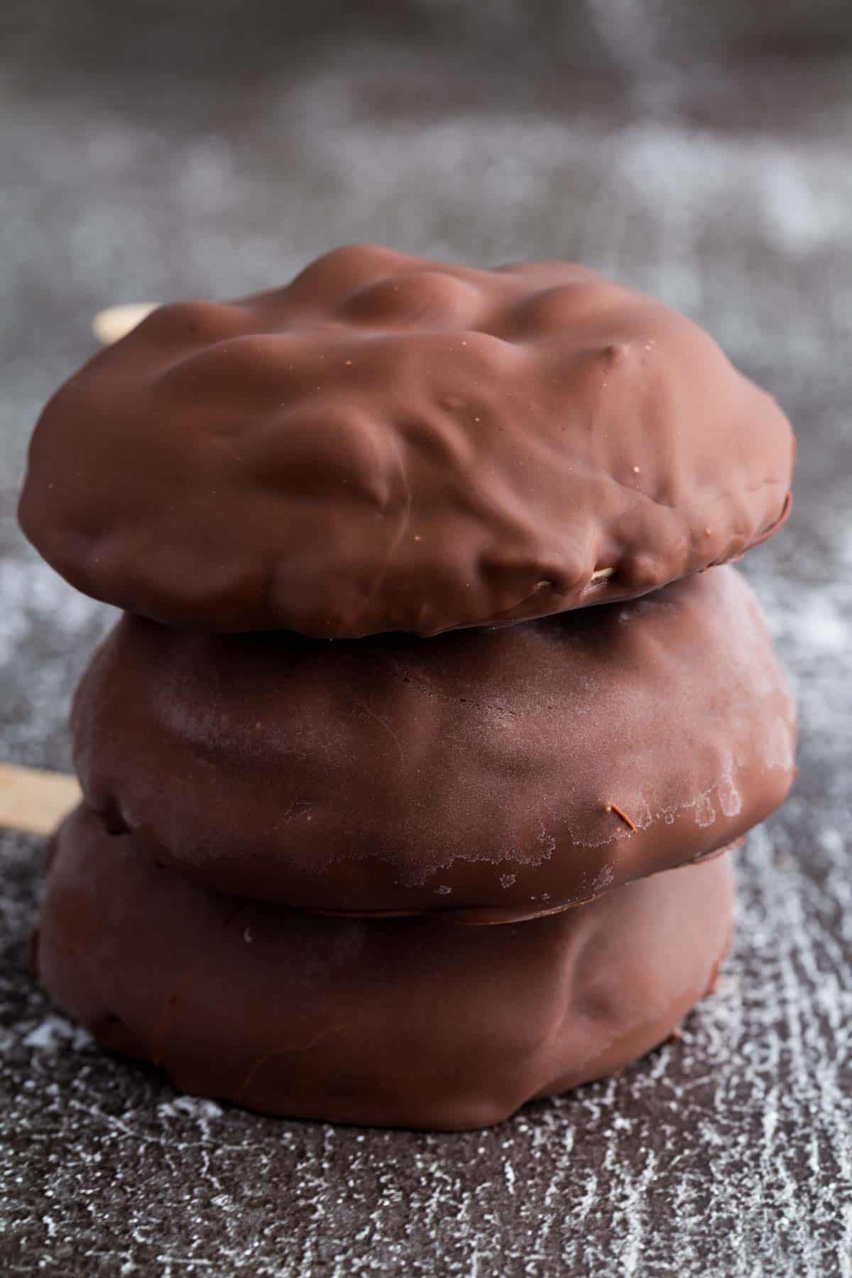 Three chocolate encased peanut butter frozen yogurt bars on a dark background.