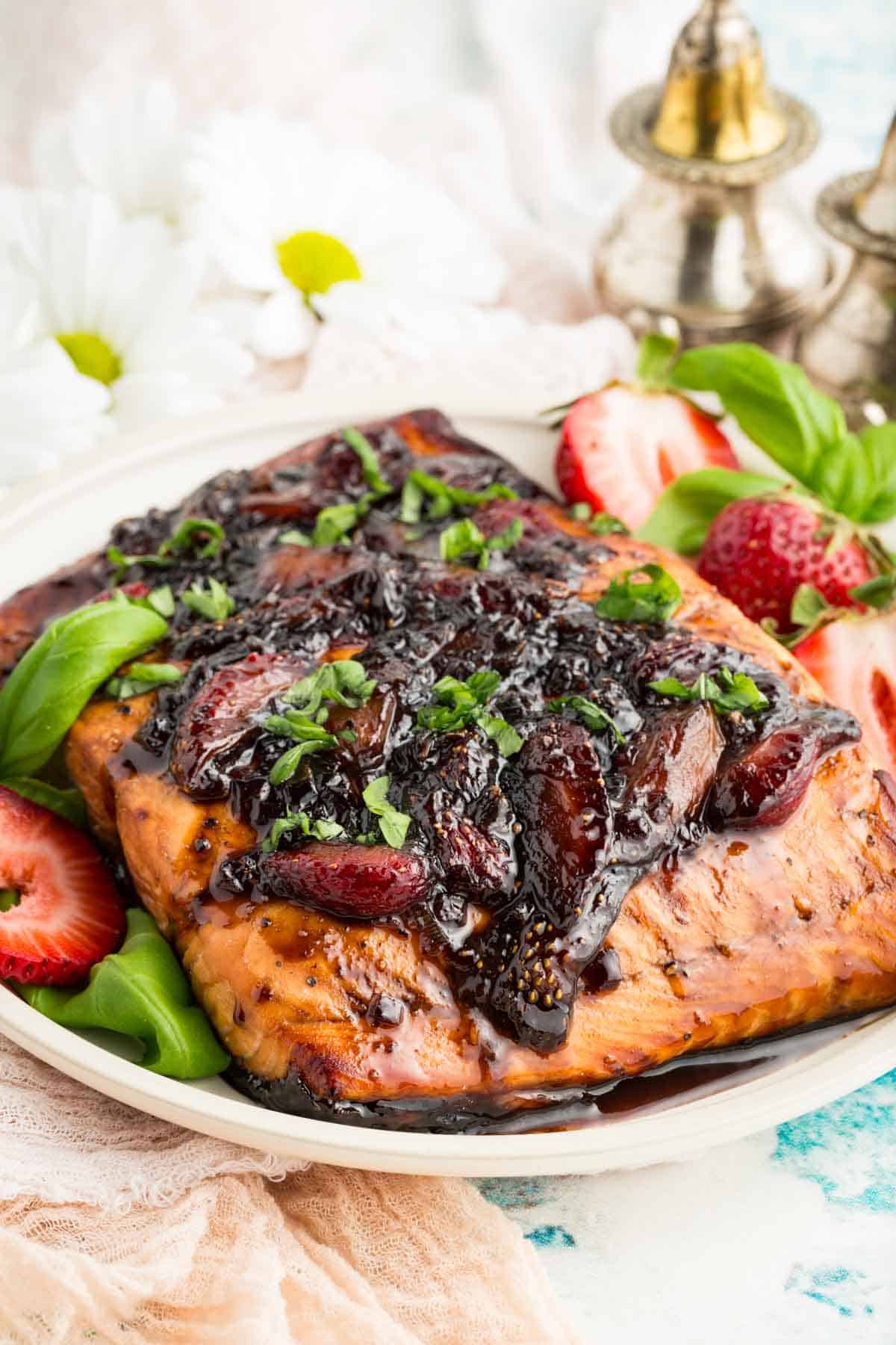 Balsamic strawberry glaze drip down a flaky piece of salmon.