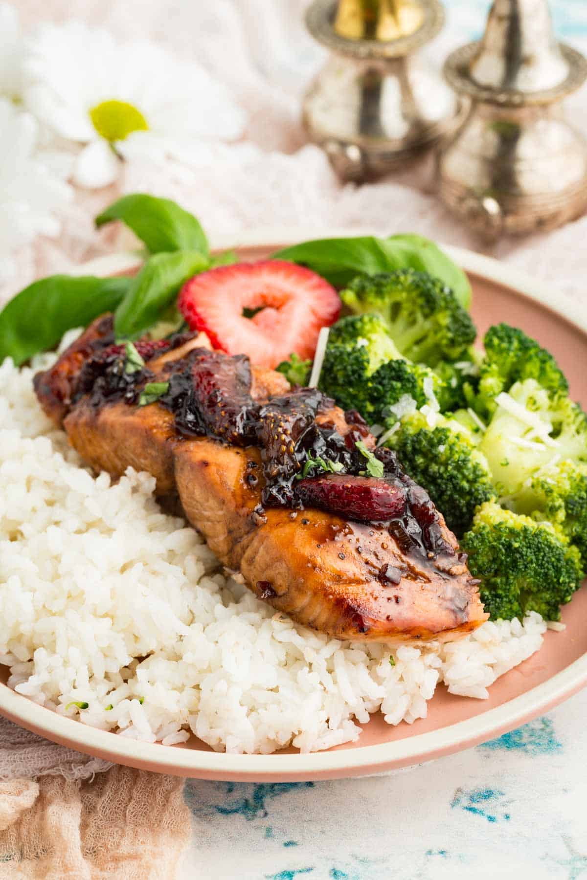 A plate holds a serving of balsamic salmon with rice and broccoli.