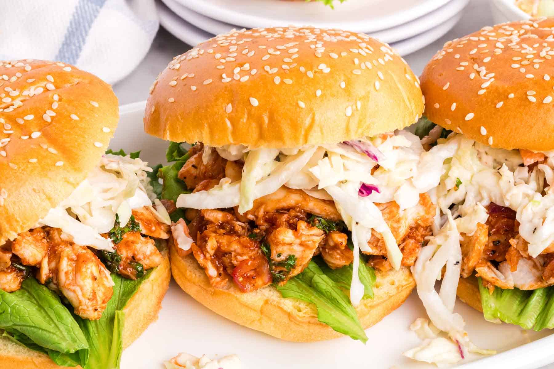 BBQ chicken sandwiches are arranged on a plate.