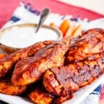 Buffalo chicken tenders are served with a bowl of dipping sauce.